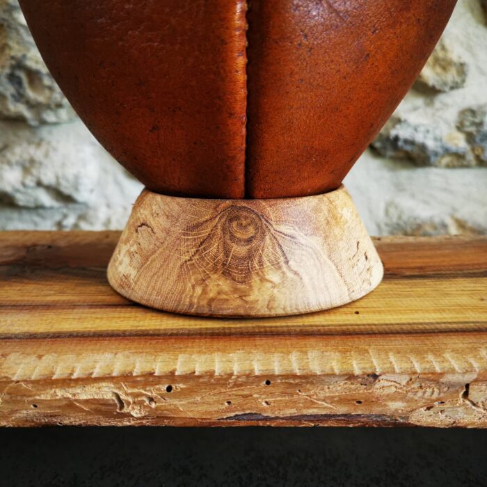 Ballon de rugby vintage en cuir posé sur un support ballon de rugby bois en chêne massif naturel, tourné à la main en France