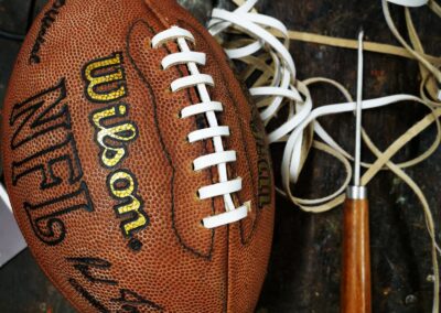 Ballon de football américain Wilson en réparation, avec passe-lacet et lacets en cuir blanc. Idéal pour illustrer la réparation d’un ballon vintage avec lacet américain authentique.