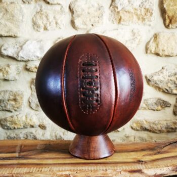 Ballon de basket brun en cuir véritable posé en déco sur un socle