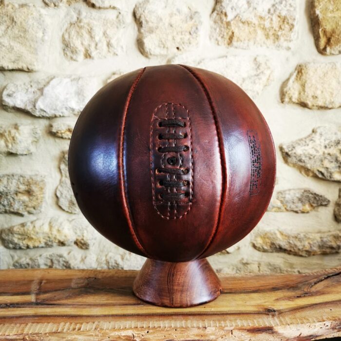 Ballon de basket brun en cuir véritable posé en déco sur un socle
