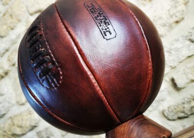 Un ballon de basket en cuir véritable marron mis en perspective sur son support