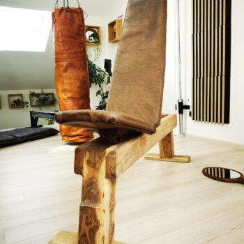 Banc de musculation haut de gamme en cuir épais et en bois dans une home gym de luxe