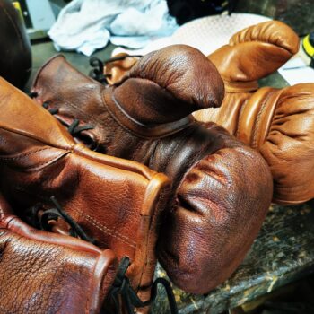 Gants de boxe en cuir vintage brun VS miel posés à l'atelier de Ben