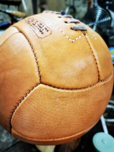 Photo macro du cuir du ballon de foot au style vintage avec patine naturelle crème