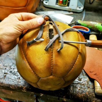 Fermeture à la main d’un médecine ball en cuir avec lacet robuste