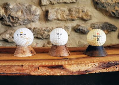 Plusieurs balles de golf posées sur des minis socles en chêne