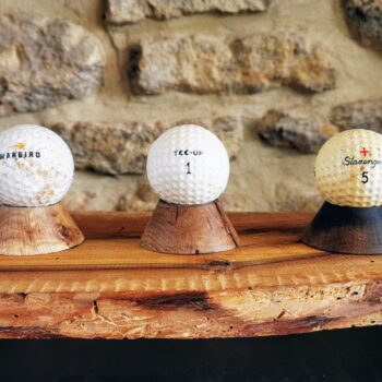 Plusieurs balles de golf posées sur des minis socles en chêne
