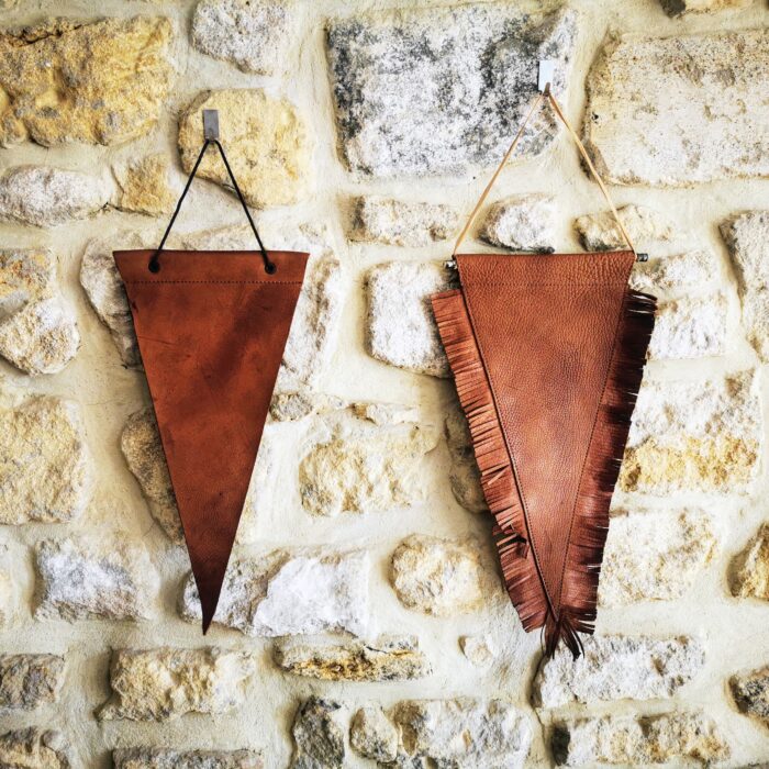 Fanions en cuir personnalisables minimaliste et avec franges accrochés sur un mur en pierre, pour basketball ou football américain