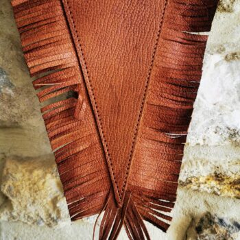 Détail de la pointe et des franges d’un fanion en cuir marron personnalisable