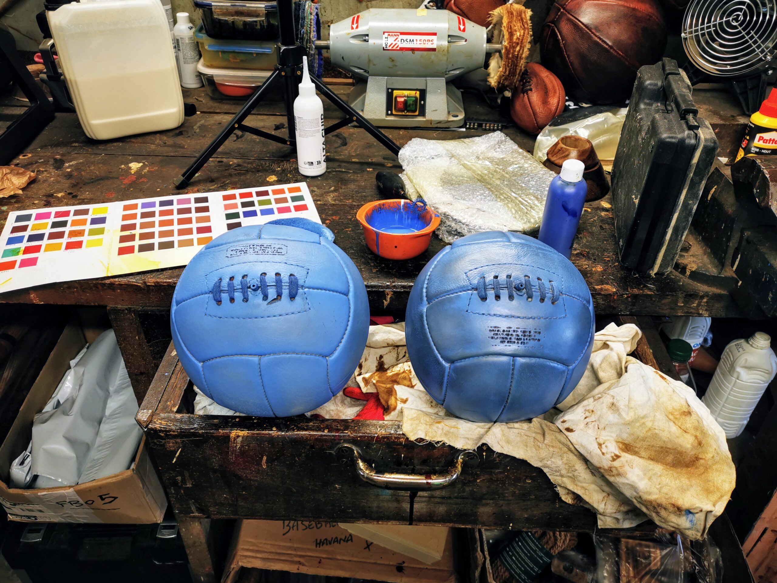 Deux ballons de football vintage en cuir personnalisés pour l’Olympique de Marseille dans l’atelier Ben & Flo